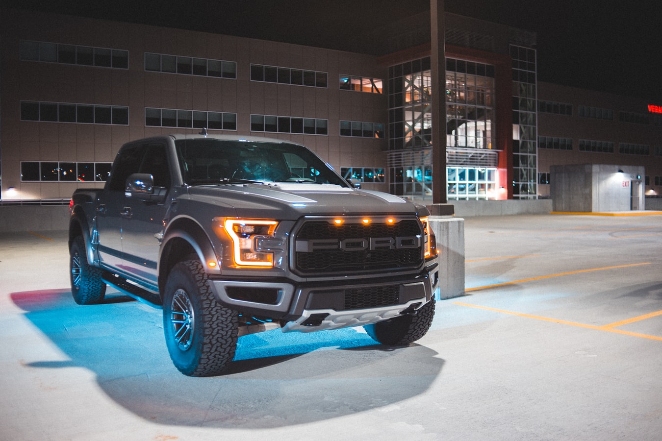 a ford f-150 raptor sitting in a parking lot