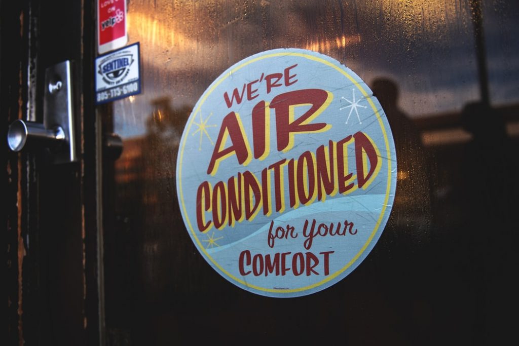 a signs that reads "We're air conditioned for your comfort."